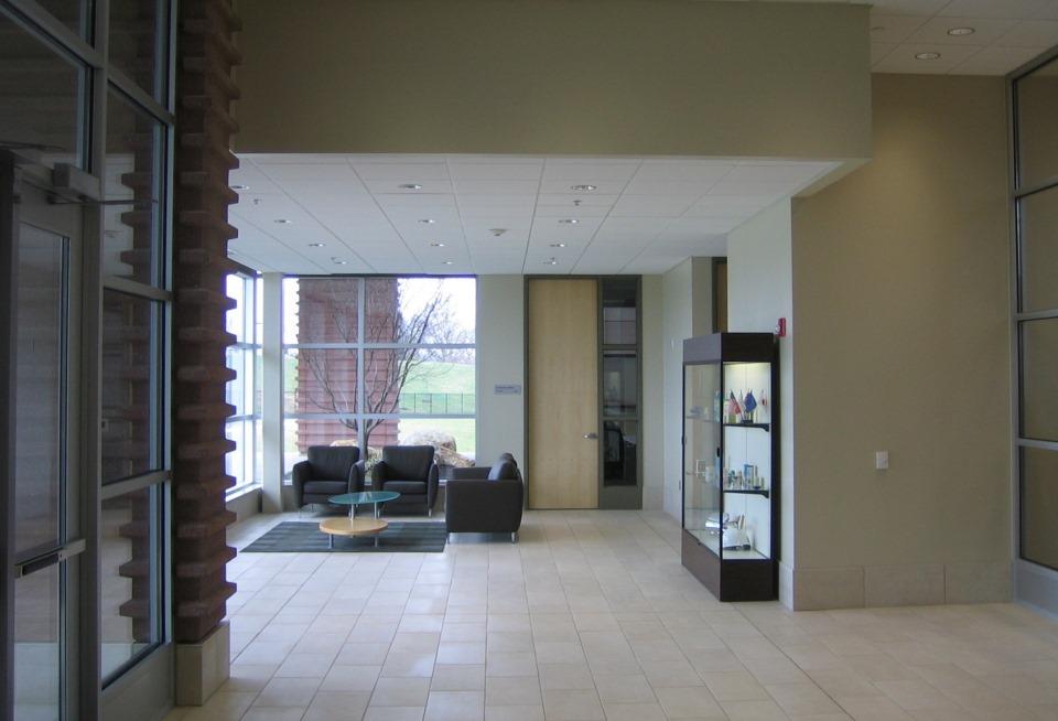 The entry pavilion interior with soft seating and meeting room beyond.